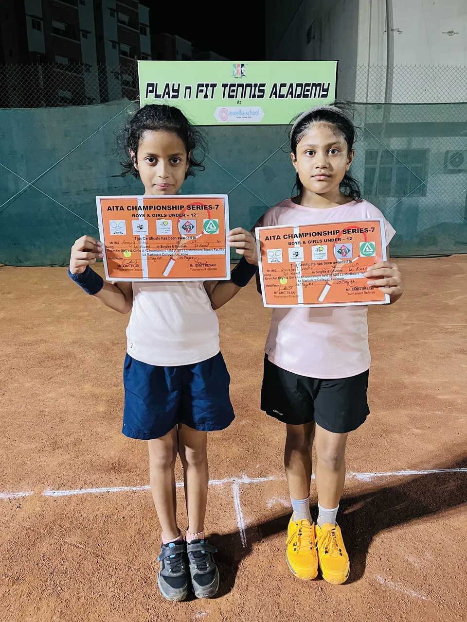 Two young players holding AITA championship certificates