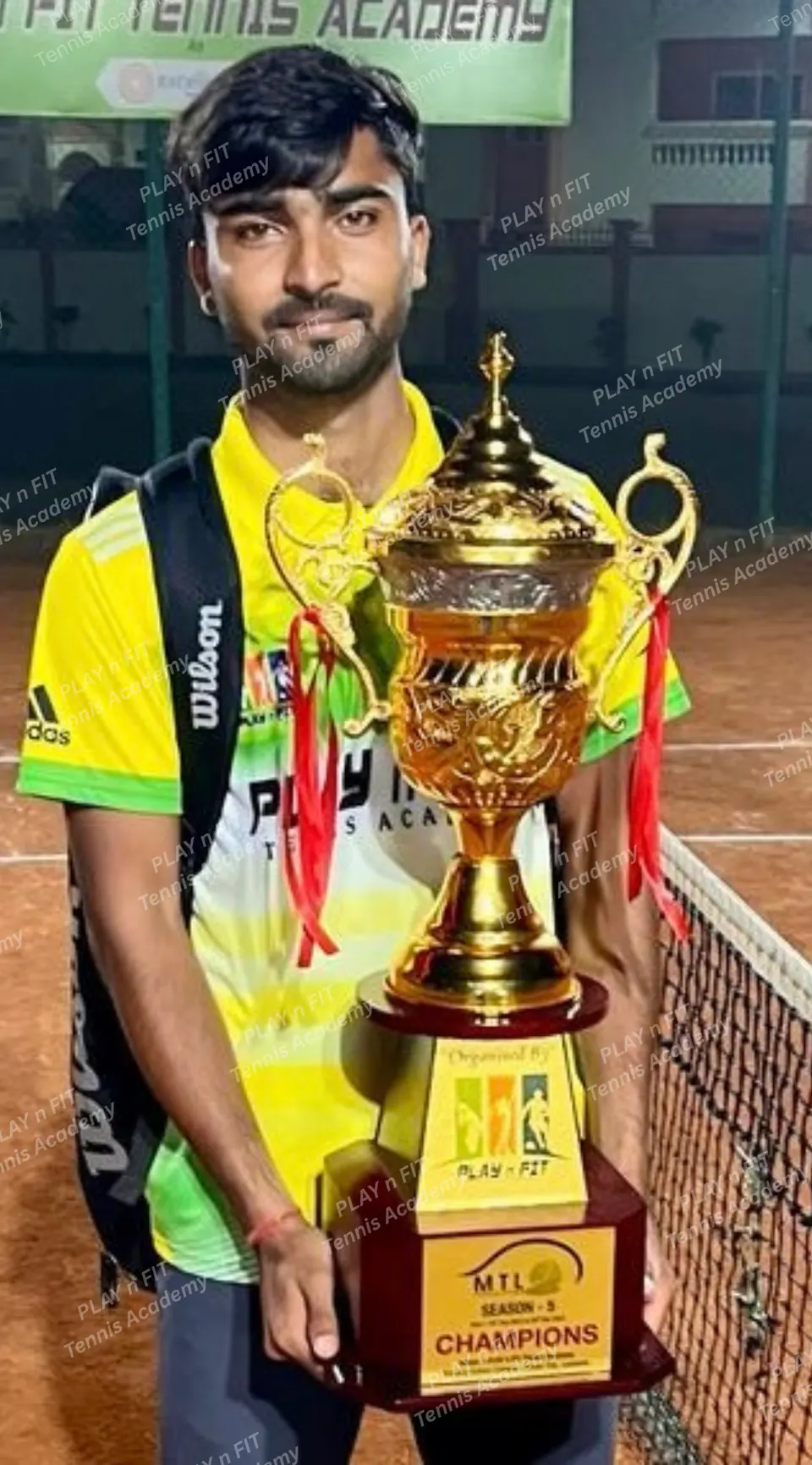 PLAY n FIT player holding a large champions trophy