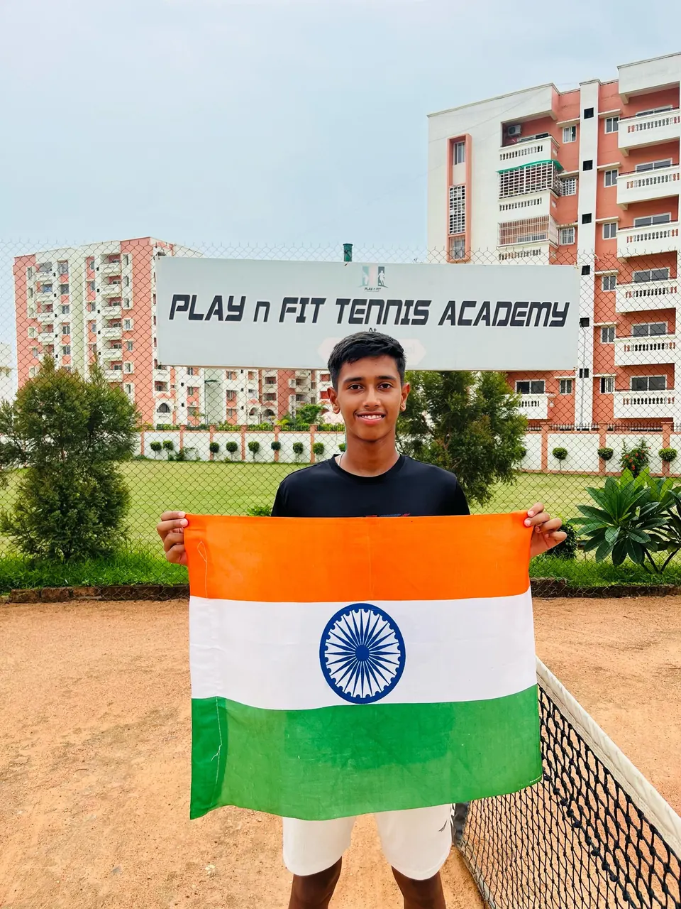 Kaustubh Singh holding the Indian flag at PLAY n FIT Tennis Academy