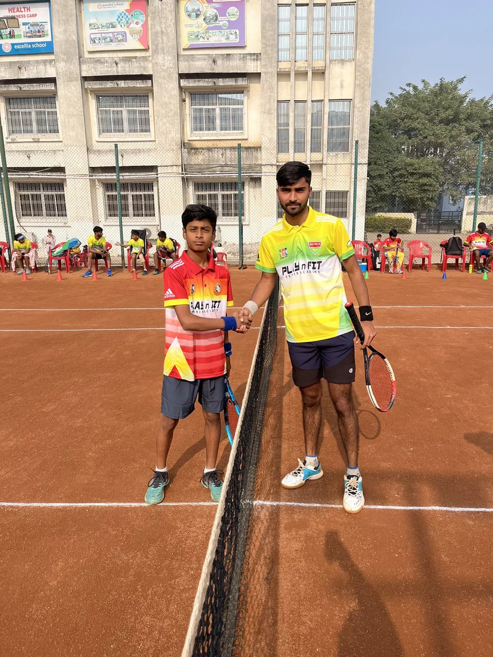 Two players shaking hands at the net after a match